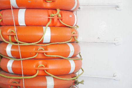 A row of Stacked Orange Lifebuoys displayed on a Ships Wallの写真素材
