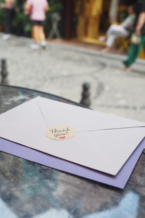 Vertical Shot of A Thank You Note featuring a charming Heart Sticker placed thoughtfully on a Table