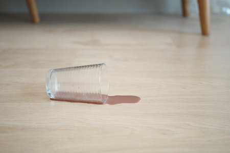 Accident Prone A Glass Has Been Spilled on the Wooden Floorの写真素材