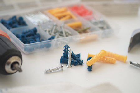 Tools and fasteners spread on a work surface for home improvement projects