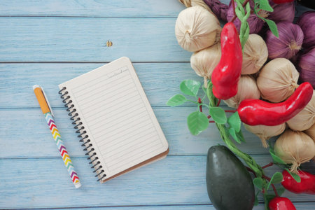 Colorful vegetables and a notepad on a wooden tableの写真素材