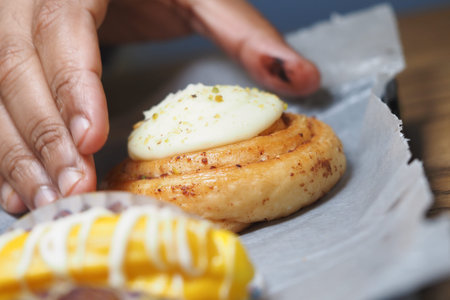 Preparing fresh cinnamon rolls with icing on top
