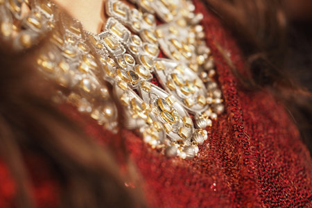 Elegant jewelry details showcased on a vibrant garmentの写真素材