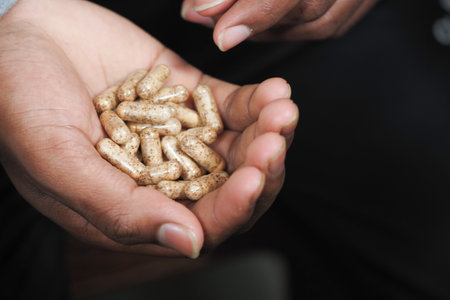 Natural supplements held in open hand during wellness demonstrationの写真素材
