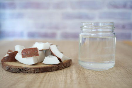 Fresh coconut pieces and coconut water on a wooden tableの写真素材