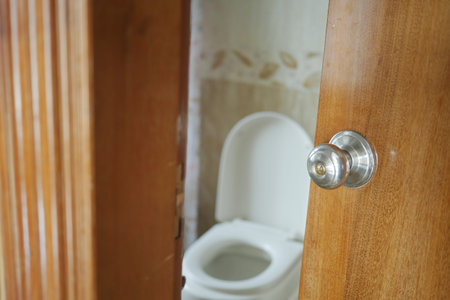 Door partially open revealing a clean bathroom environment