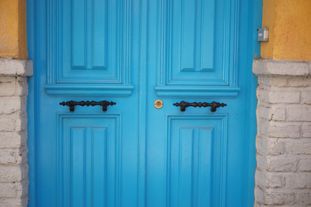 Beautiful blue wooden door with ornate handles in sunny location