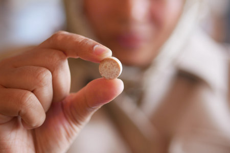 Woman holds small round tablet in hand at indoor location