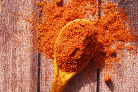 Bright orange spice on wooden surface with rustic background