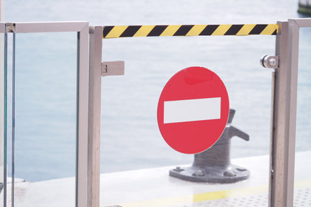 Gate with no entry sign near harbor in bright daylightの写真素材