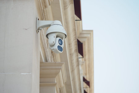 Security camera mounted on a building during daylight in an urban area