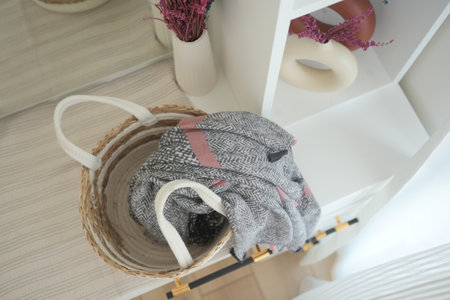 Cozy scarf draped over a woven basket in a modern entrywayの写真素材