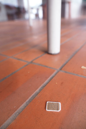 a phone sim card dropped on a tiles floor. lost sim card concept
