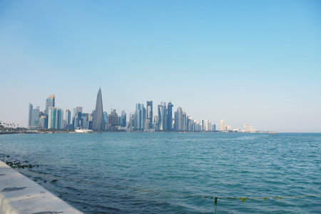 Qatar City skyline rises over calm waters during bright sunny day