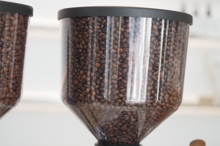 Coffee beans displayed in transparent storage containers at a cafe