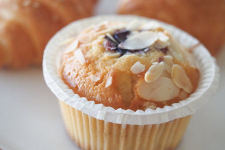 Muffin topped with sliced almonds on a plateの写真素材