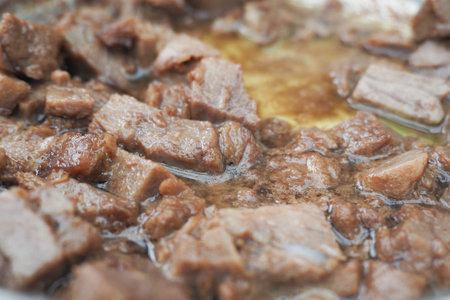 Savory beef cooking in a pan over moderate heat in a kitchen setting