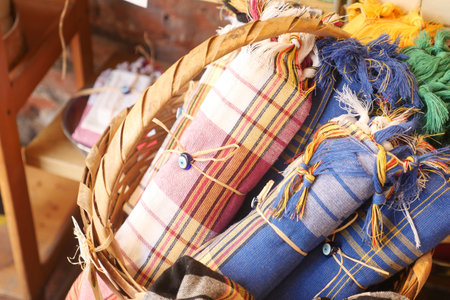 Colorful handmade textiles in a woven basket at a marketの写真素材