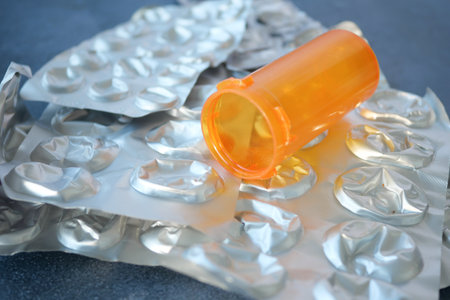 Prescription medication container and empty blister packs on tableの写真素材