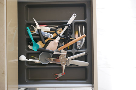 Close up of messy kitchen utensil drawer.の写真素材