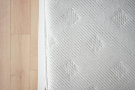 Mattress on wooden floor in modern bedroom setting during daytime