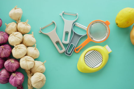 Kitchen utensils and vegetables arranged on a turquoise surfaceの写真素材