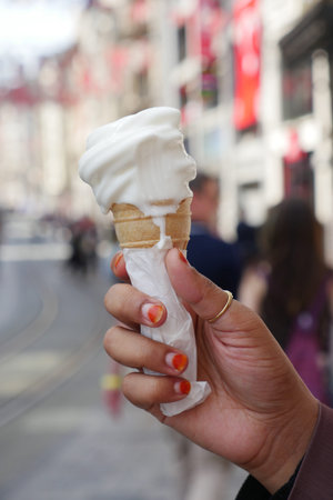 Holding a MouthWatering and Delicious Ice Cream Cone While Strolling Along a Sunny City Street