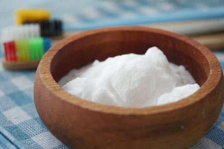 Baking soda bowl with colorful toothbrushes on a tableclothの写真素材