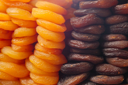 Dried apricots and figs displayed in vibrant colors at marketの写真素材