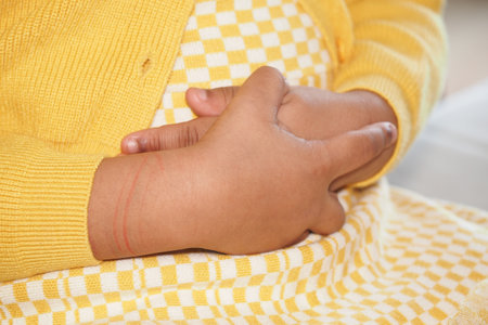 Child experiencing discomfort while holding stomach at homeの写真素材