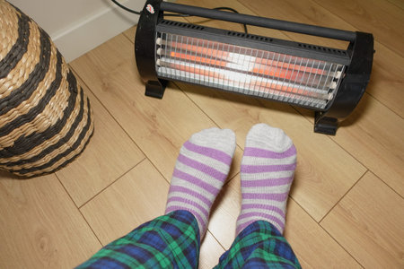 Cozy indoor setting with warm heater and striped socks on wooden floor