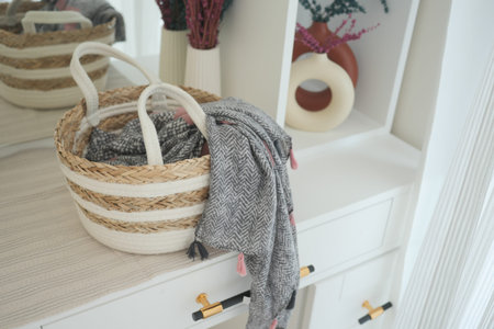Decorative storage basket with a cozy scarf and warm decor elementsの写真素材