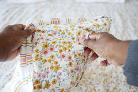 Preparing a floral pillowcase for a cozy bed setting at home