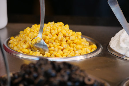 Sweet corn served in a metallic bowl at a food stall