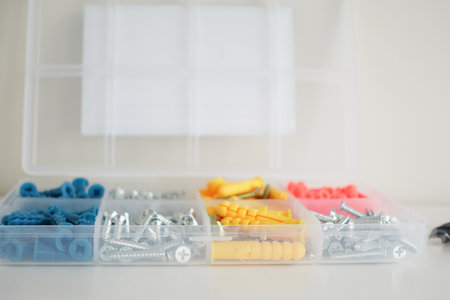 Assorted screws and fasteners neatly arranged in a storage containerの写真素材