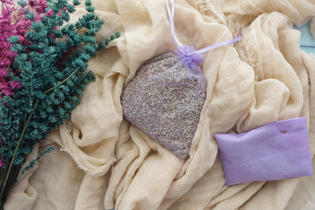 Lavender sachet on rustic fabric with dried flowers nearbyの写真素材