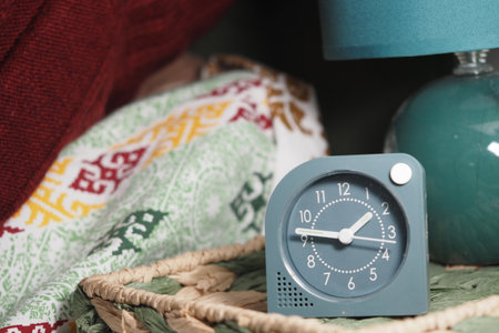 Soft morning light illuminates a vintage clock on a cozy nightstandの写真素材