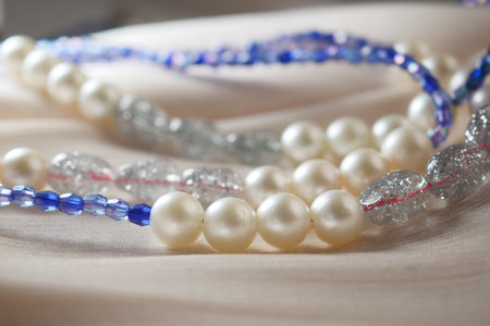 Elegant handcrafted necklaces displayed on soft fabric surfaceの写真素材