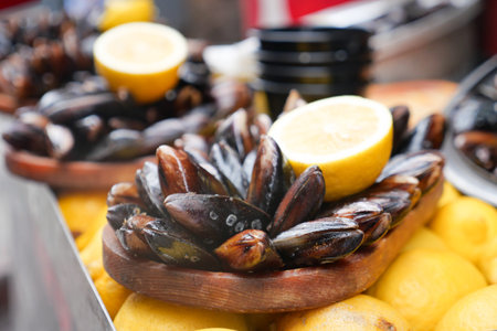 Platter full of mussels with lemon slices ready for customers to enjoyの写真素材