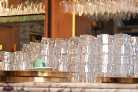 Stacked glassware in a busy cafe during the afternoon rushの写真素材