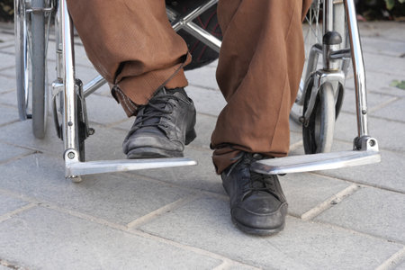 Wheelchair user resting outdoors with comfortable footwearの写真素材