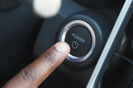 Hand pressing power button inside a car for ignitionの写真素材