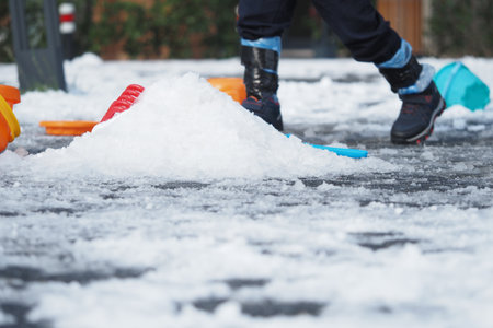 Children playing with snow in a backyard during winter afternoonの写真素材