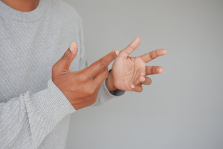 Hands gesturing in a creative expression against a simple backdropの写真素材