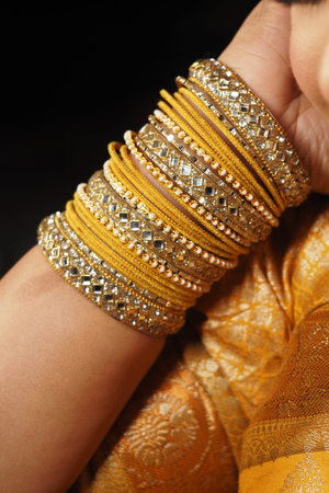 Beautiful golden bracelets sparkling on a wrist at a festive event