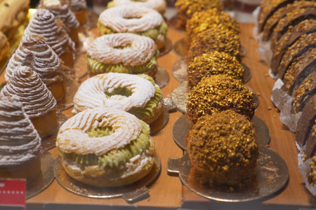 Delicious pastries displayed in a bakery on a busy afternoonの写真素材