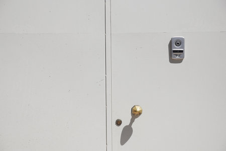 Front door with gold knob and modern lock in bright sunlightの写真素材
