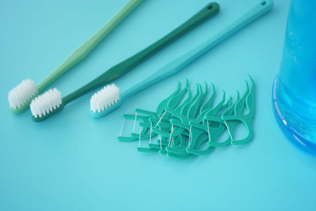 Dental hygiene tools arranged on a turquoise background