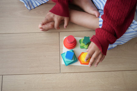 Child engaged in learning activity with colorful shape puzzle