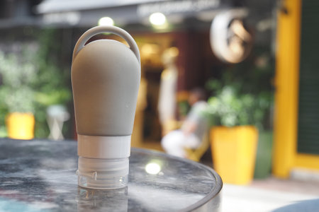 Squeeze bottle on a table in a vibrant outdoor cafe settingの写真素材